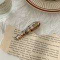 Detail of amber marble resin hair clip on vintage paper backdrop for a chic look - Black