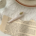 Detail of pink marble resin hair clip with gold logo on cream textured background - Moonlight White