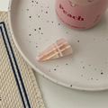Detail einer rosa karierten Haarklammer auf einem weißen Keramiktablett für süßen Look - Lange Dreieck Haarklammer