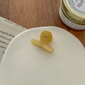 Detail shot of mini amber acetate hair claw with 'FRANCE handmade' engraving - Milk Yellow