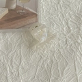 Dettaglio di una mini clip per capelli perlata crema su tessuto bianco testurizzato - Bianco AB