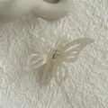 Détail d'une pince à cheveux papillon en acétate blanc crème avec ressort en métal doré - Pince Papillon Sirène