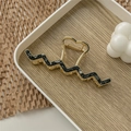 Detailed close-up of a gold metal hair claw with marble texture and heart-shaped handle - Ink Painting