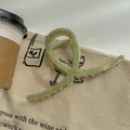 Vista dettagliata di una pinza per capelli a fiori verde oliva con molla su borsa di tela - Verde Acquerellato