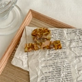 Detail of tortoise shell acetate claw clip with round hollow design on wooden tray - Golden Years