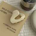 Irregular heart-shaped ivory hair claw clip on book in minimalist lifestyle setting - Pure White