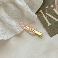 Détail d'une barrette en acétate rose marbré avec pince crocodile en métal doré - Rose Métallique