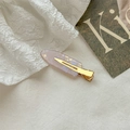 Detail of translucent purple resin hair clip with gold metal clasp on white fabric - Metallic Purple