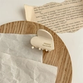 Détail d'une pince à cheveux cœur en acétate avec imprimé France Handmade sur plateau - Blanc