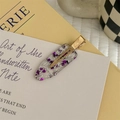 Dettaglio di un fermaglio trasparente con paillettes a cuore viola su carta d'arte - Viola Trasparente
