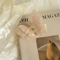Detail of a pearlescent butterfly hair claw clip with a shimmering double-layered design - Yellow