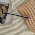 Detail of vintage blue-green metal hair clip with pink resin bow and engraved branding - Pink
