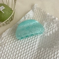 Dettaglio della pinza per capelli in acetato marmorizzato verde menta su carta - Semicircolare Ciano