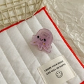 Close-up of a small purple translucent octopus hair claw clip with cute smiling face detail - Octopus