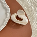 Dettaglio molletta per capelli a cuore irregolare in acetato con trama marmorea - Bianco Sporco