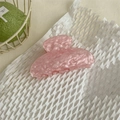 Pinza per capelli in acetato rosa marmorizzato su sfondo di carta a nido d'ape - Unico Rosa