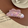 Gros plan d'une pince à cheveux nuage avec fini nacré rose iridescent sur fond en tissu - Violet Métallique