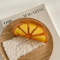 Vue détaillée d'une pince à cheveux orange sur plateau bois avec magazines de mode - Orange
