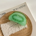 Détail macro d'une pince à cheveux en acrylique en forme de kiwi au fini vert translucide - Kiwi