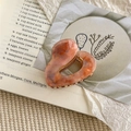 Close-up of heart-shaped hair claw clip in orange pink marble acetate with gold glitter - Hollow Heart Style / Reddish Brown