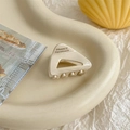 Detail van de crèmekleurige acetaat driehoek haarklem met France Handmade tekst - crème