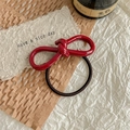Macro detail of glossy dark red acetate bow hair tie with black elastic band on paper - Glossy Wine Red / Burgundy