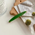 Olive green acetate hair clip with gold Creation France logo on elegant wooden tray - Green