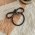 Detail view of acetate bow hair tie with tortoiseshell pattern on brown elastic band - Tortoiseshell / Lake Blue Coffee