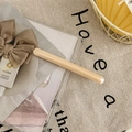 Detailed view of a minimalist cream acetate hair clip on a textured linen background - Milky White