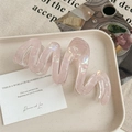 Détail d'une pince à cheveux rose ondulée à fini irisé sur un plateau décoratif - Rose Irisé 13cm