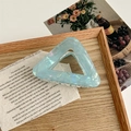 Detail of light blue acetate triangle hair claw clip with pearlescent finish on linen - Iridescent Blue Green