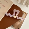 Detail of a large pink iridescent heart-shaped hair claw clip with golden metal spring - Metallic Purple