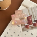 Detail view of the elegant pink iridescent hair claw clip with a glossy finish - Iridescent Orange