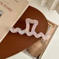Detailed view of iridescent heart-shaped hair claw clip with wavy edges in French style - Metallic Pink