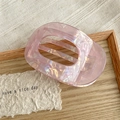 Detailed macro view of pink marble acetate hair claw clip with colorful pearlescent finish - Metallic Purple