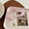 Detail of a large pink iridescent cloud-shaped hair claw clip on a stylish desk setting - Metallic Purple