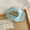 Detail shot of light blue marble acetate hair claw clip with cutout rectangular design - Iridescent Blue Green