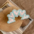 Detalle de pinza para el pelo azul claro con corazones de cuadros rosa sobre madera - Pinza de Múltiples Corazones