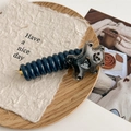 Detail eines süßen Bären-Haargummis mit blauer Spirale und goldener Clip-Basis - Schwarzgrau Bär