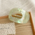 Macro detail of large iridescent green acetate hair claw clip with oval hollow design - Metallic Green