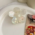 Macro shot of white acetate flower hair claw with pearl-like luster in ceramic tray - Ice White