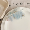 Detail view of a translucent blue butterfly hair claw clip with sandy texture finish - Blue Stripe