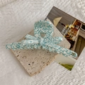 Nahaufnahme der blauen und weißen Haarklammer aus Acetat mit goldener Handmade-Aufschrift - Feine Verpackung Stil / Blau Punktiert