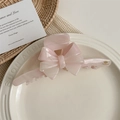 Detailed close-up of large pink bow hair claw clip on a decorative white ceramic tray - Pink Striped