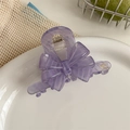 Vue détaillée de la pince à cheveux noeud en acétate lavande faite main sur plat en céramique - Violet