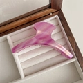 Detail of a large acetate claw clip featuring purple marble texture and golden logo - Rose Red