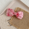 Nahaufnahme der rosa Marmor-Haarklammer mit glänzenden Strasssteinen und goldenem VD-Logo - Rosa