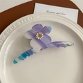 Détail d'une pince à cheveux fleurie en acétate avec logo doré et dégradé élégant - Bleu Violet Rayé