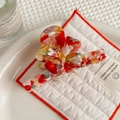 Detailed macro view of handmade colorful marbled acetate hair claw clip on ceramic tray - Rainbow