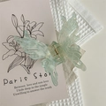 Close-up of mint green butterfly hair claw clip with fine glitter on waffle fabric - Light Green